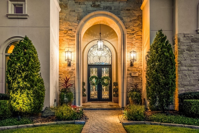 27 S Glenwild Cir, The Woodlands, TX 77389 - entrance to property with stone siding, stucco siding, and french doors