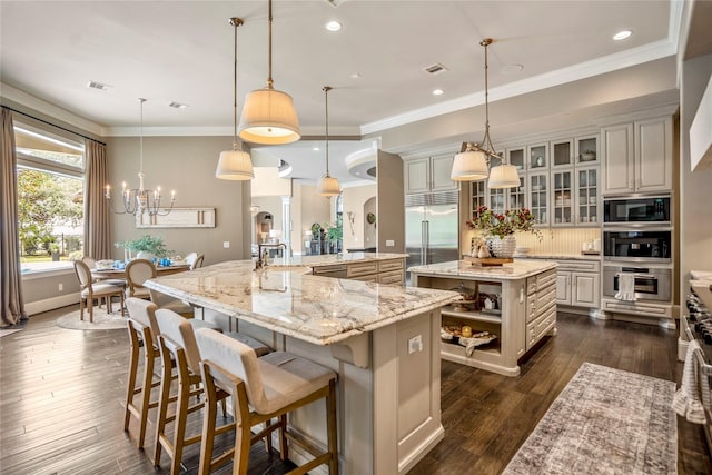 27 S Glenwild Cir, The Woodlands, TX 77389 - kitchen with built in appliances, a spacious island, open shelves, a chandelier, and dark wood-type flooring