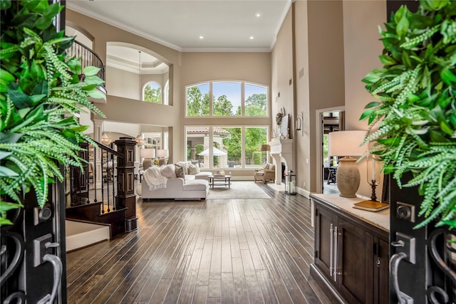 27 S Glenwild Cir, The Woodlands, TX 77389 - living area featuring stairs, plenty of natural light, arched walkways, dark wood-type flooring, and a high ceiling