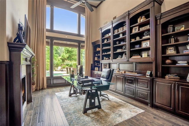 27 S Glenwild Cir, The Woodlands, TX 77389 - home office featuring a towering ceiling, ceiling fan, hardwood / wood-style flooring, and a high end fireplace