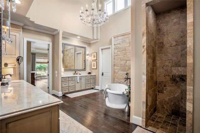 27 S Glenwild Cir, The Woodlands, TX 77389 - full bathroom with ornamental molding, vanity, hardwood / wood-style floors, a freestanding tub, and tiled shower
