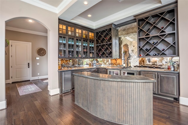 27 S Glenwild Cir, The Woodlands, TX 77389 - indoor wet bar with ornamental molding, arched walkways, backsplash, dark wood-style flooring, and recessed lighting