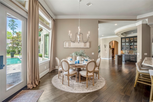 27 S Glenwild Cir, The Woodlands, TX 77389 - dining space with arched walkways, dark wood-style floors, plenty of natural light, a chandelier, and ornamental molding