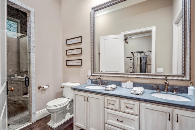 27 S Glenwild Cir, The Woodlands, TX 77389 - bathroom featuring a shower stall, double vanity, wood finished floors, and a ceiling fan