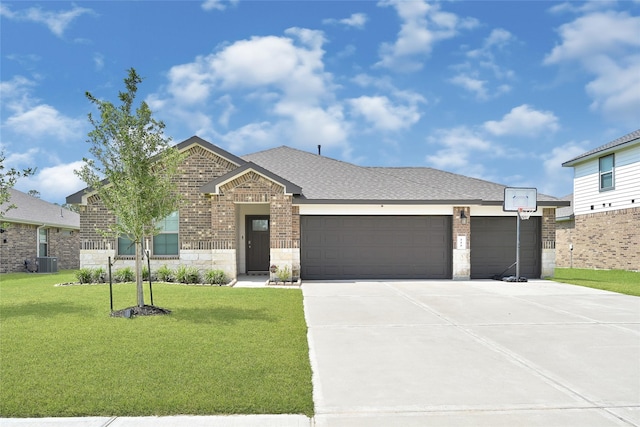225 Big Spring Dr, Anahuac, TX 77514 - view of front of home featuring a front yard, concrete driveway, an attached garage, brick siding, and stone siding