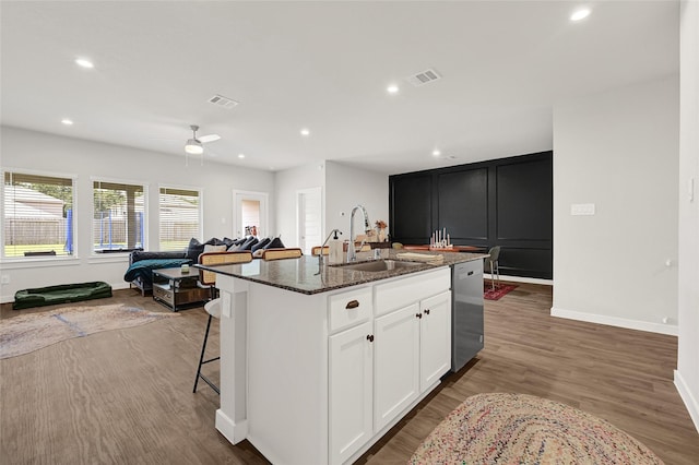 225 Big Spring Dr, Anahuac, TX 77514 - kitchen with dishwasher, dark stone counters, open floor plan, ceiling fan, and a kitchen island with sink