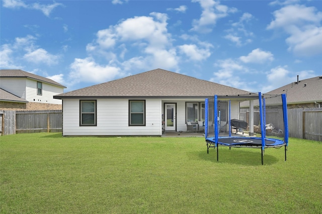 225 Big Spring Dr, Anahuac, TX 77514 - rear view of property with a fenced backyard, a trampoline, and a shingled roof