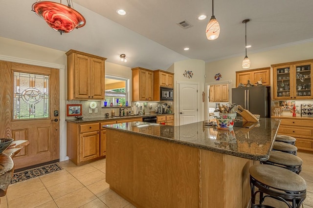 33 Lakeside, Trinity, TX 75862 - kitchen with black appliances, a kitchen island, a kitchen bar, glass insert cabinets, and light tile patterned flooring