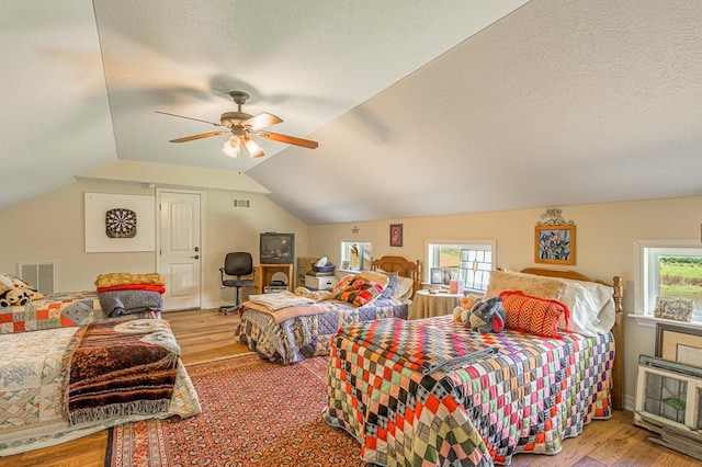 33 Lakeside, Trinity, TX 75862 - bedroom with wood finished floors, lofted ceiling, a ceiling fan, and a textured ceiling