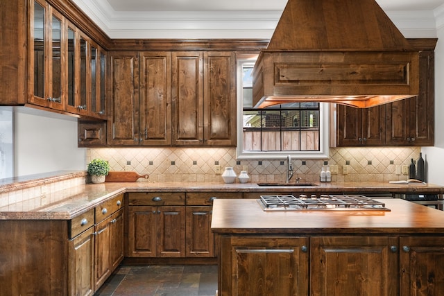 1013 Mulberry Ln, Bellaire, TX 77401 - kitchen featuring custom exhaust hood, stainless steel gas stovetop, butcher block counters, decorative backsplash, and dark stone finish flooring