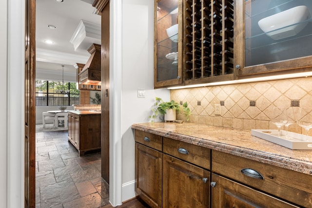 1013 Mulberry Ln, Bellaire, TX 77401 - bar area with stone tile floors, crown molding, premium range hood, backsplash, and recessed lighting