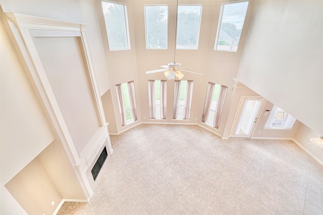 1814 Ferndale Lake Ct, Richmond, TX 77406 - unfurnished living room featuring plenty of natural light, a towering ceiling, a ceiling fan, and light tile patterned flooring