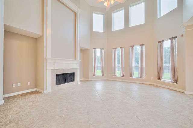 1814 Ferndale Lake Ct, Richmond, TX 77406 - unfurnished living room featuring a tile fireplace, light tile patterned floors, ceiling fan, and a high ceiling