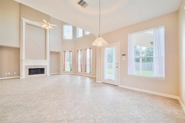 1814 Ferndale Lake Ct, Richmond, TX 77406 - unfurnished living room with healthy amount of natural light, a tiled fireplace, a ceiling fan, and light tile patterned flooring