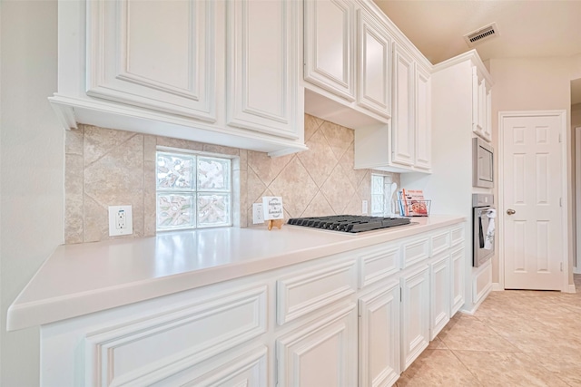 1814 Ferndale Lake Ct, Richmond, TX 77406 - kitchen featuring stainless steel appliances, tasteful backsplash, white cabinetry, and light countertops