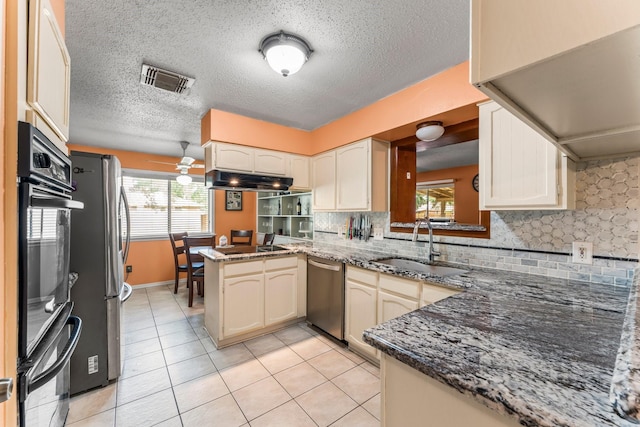 6103 Sunnygate Dr, Spring, TX 77373 - kitchen with stainless steel appliances, a peninsula, light tile patterned floors, decorative backsplash, and a textured ceiling