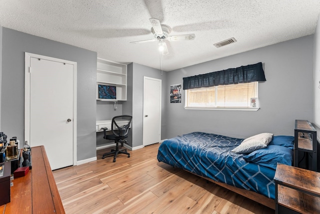 6103 Sunnygate Dr, Spring, TX 77373 - bedroom featuring wood finished floors, a textured ceiling, ceiling fan, and a desk
