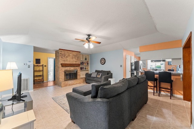 6103 Sunnygate Dr, Spring, TX 77373 - living room with light tile patterned floors, ceiling fan, and a fireplace
