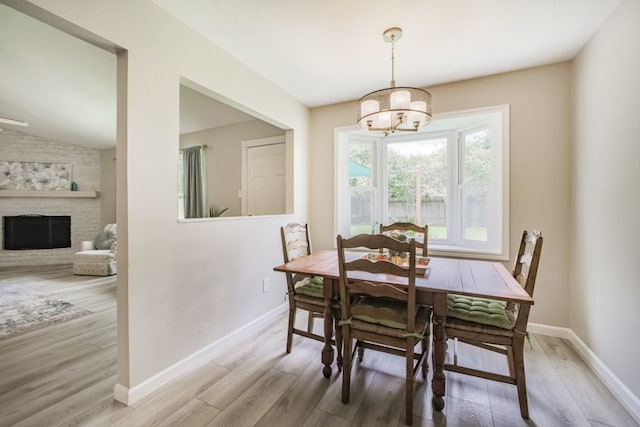 22002 Silver Lode Dr, Katy, TX 77450 - dining room with a chandelier, wood finished floors, a fireplace, and vaulted ceiling