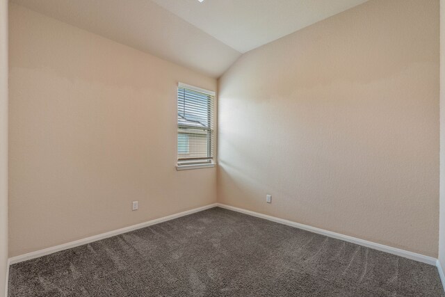 11053 Patriot Ct, Cleveland, TX 77328 - empty room with dark carpet and vaulted ceiling