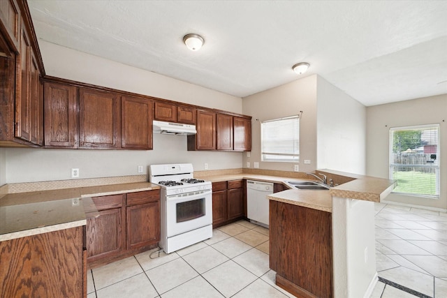 8101 Gallahad St Unit A B, Houston, TX 77078 - kitchen with white appliances, under cabinet range hood, a peninsula, light tile patterned flooring, and light countertops