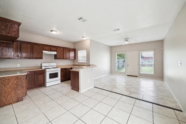 8101 Gallahad St Unit A B, Houston, TX 77078 - kitchen featuring white gas range, light countertops, light tile patterned floors, a ceiling fan, and under cabinet range hood