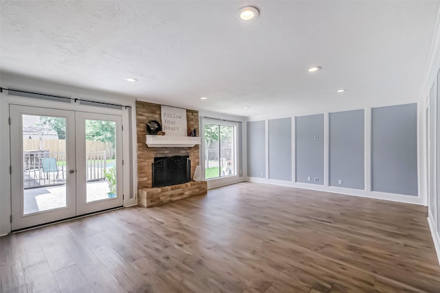 1711 Earl Of Dunmore St, Katy, TX 77449 - unfurnished living room featuring french doors, wood finished floors, recessed lighting, and a brick fireplace
