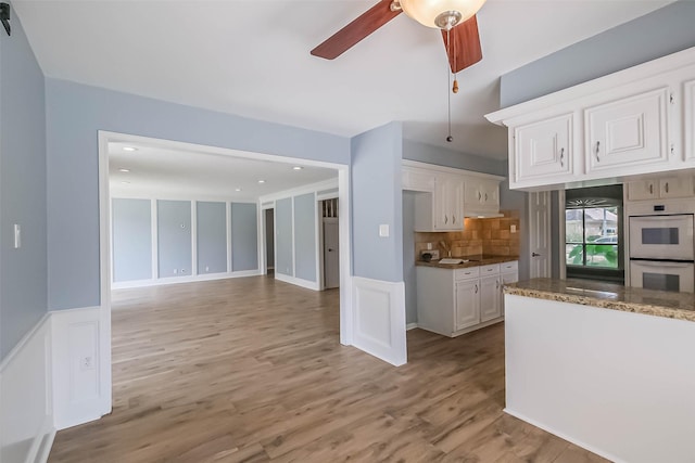 1711 Earl Of Dunmore St, Katy, TX 77449 - kitchen with white cabinetry, ceiling fan, light wood-style floors, double oven, and tasteful backsplash