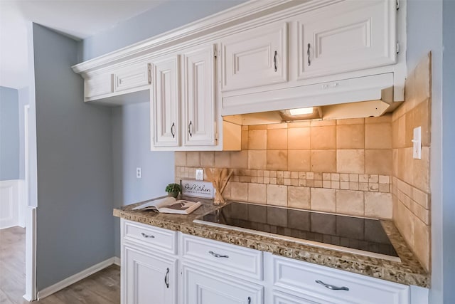 1711 Earl Of Dunmore St, Katy, TX 77449 - kitchen featuring black electric cooktop, white cabinets, backsplash, wood finished floors, and dark stone countertops