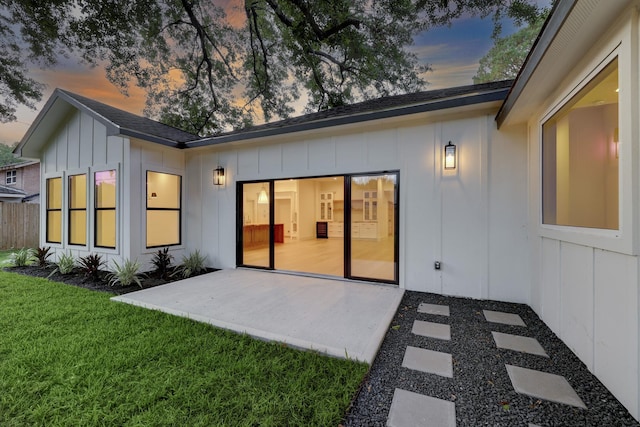 6110 Yarwell Dr, Houston, TX 77096 - back of house at dusk with board and batten siding and a patio area