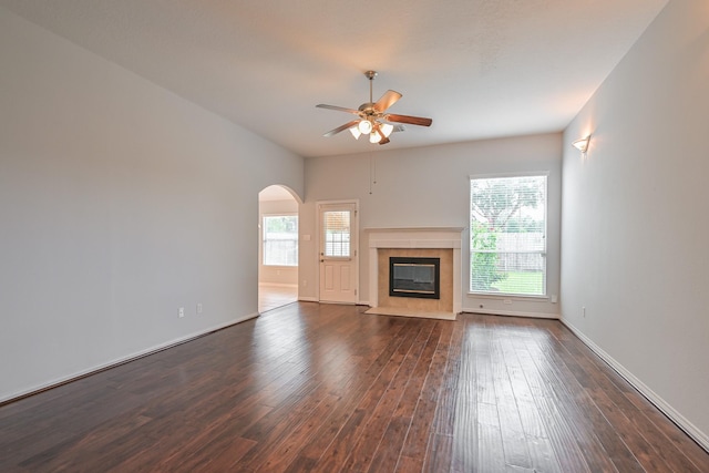 1518 Bugle Run Dr, Katy, TX 77449 - unfurnished living room with ceiling fan, dark wood finished floors, arched walkways, and a fireplace