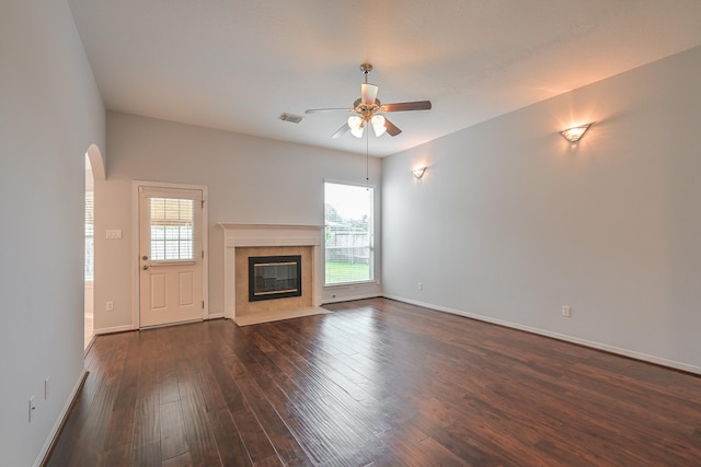 1518 Bugle Run Dr, Katy, TX 77449 - unfurnished living room featuring ceiling fan, healthy amount of natural light, arched walkways, and dark wood-type flooring