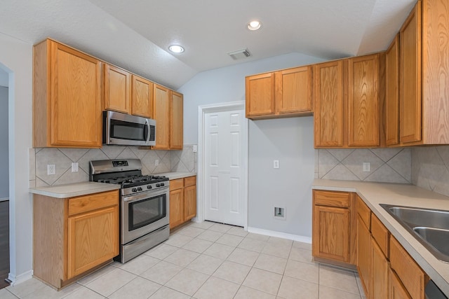 1518 Bugle Run Dr, Katy, TX 77449 - kitchen featuring appliances with stainless steel finishes, vaulted ceiling, light countertops, backsplash, and light tile patterned flooring