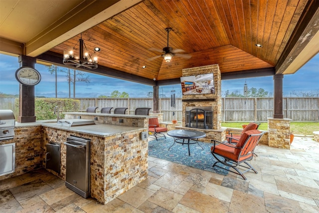 11443 Northam Dr, Tomball, TX 77375 - fenced backyard with an outdoor stone fireplace, exterior kitchen, a patio, a gazebo, and a ceiling fan