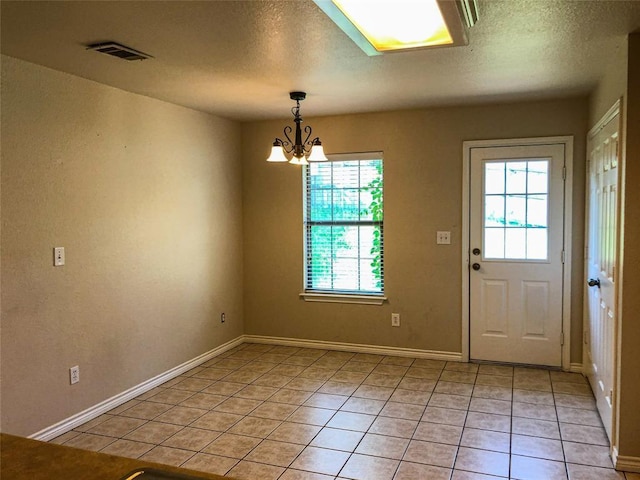 113 Bolero Way, Huntsville, TX 77340 - unfurnished dining area featuring a chandelier, light tile patterned floors, and a textured ceiling