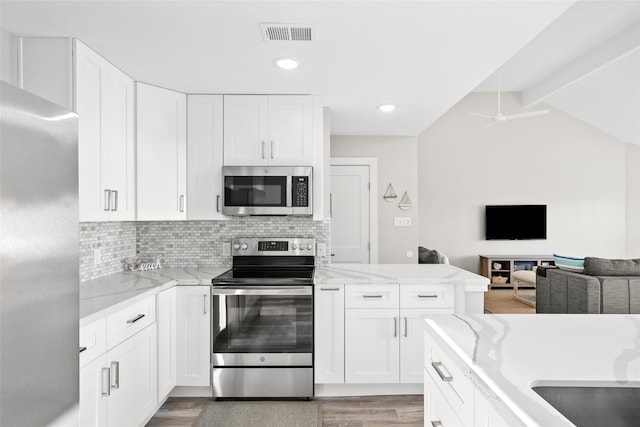 17711 Termini San Luis Pass Rd, Galveston, TX 77554 - kitchen with stainless steel appliances, light wood-style floors, open floor plan, white cabinets, and recessed lighting