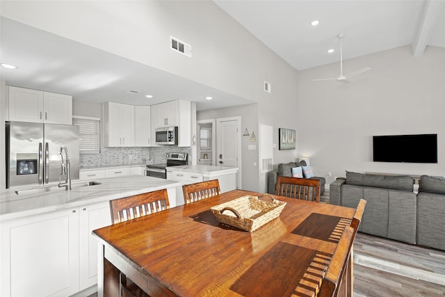 17711 Termini San Luis Pass Rd, Galveston, TX 77554 - dining room featuring beam ceiling, high vaulted ceiling, ceiling fan, light wood-style flooring, and recessed lighting