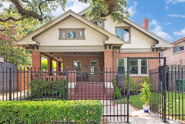3404 Audubon Pl, Houston, TX 77006 - view of front of property featuring stucco siding, brick siding, a chimney, covered porch, and a gate