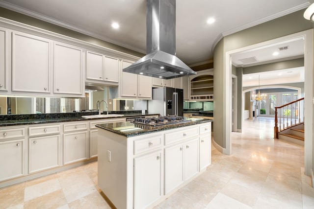 2217 Dunraven Ln, Houston, TX 77019 - kitchen with island exhaust hood, ornamental molding, stainless steel appliances, arched walkways, and a center island