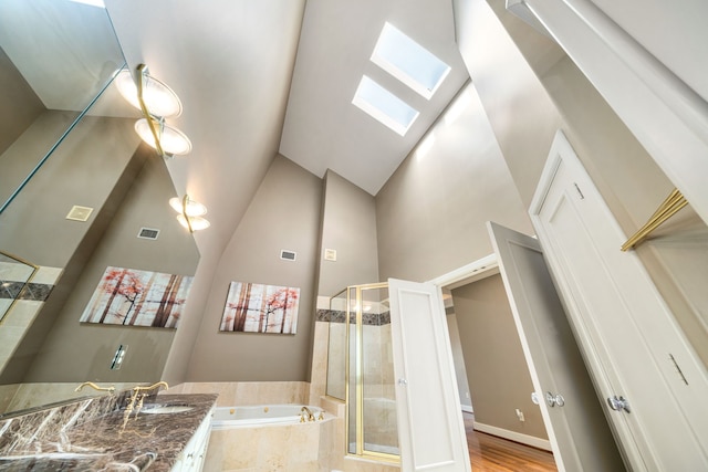 2217 Dunraven Ln, Houston, TX 77019 - bathroom with a skylight, a jetted tub, a shower stall, vanity, and high vaulted ceiling