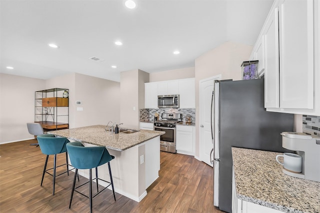 4310 Fornari Ln, Katy, TX 77449 - kitchen featuring stainless steel appliances, tasteful backsplash, dark wood finished floors, white cabinets, and recessed lighting