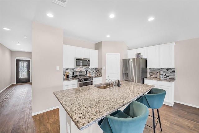 4310 Fornari Ln, Katy, TX 77449 - kitchen with appliances with stainless steel finishes, a kitchen island with sink, dark wood-style floors, tasteful backsplash, and recessed lighting