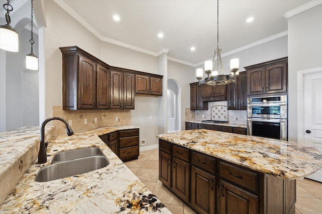 2508 Siskin Trl, League City, TX 77573 - kitchen featuring stainless steel appliances, tasteful backsplash, a center island, dark brown cabinets, and light stone counters