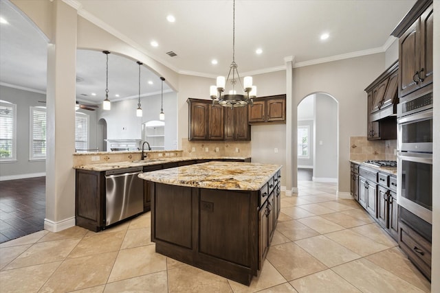 2508 Siskin Trl, League City, TX 77573 - kitchen featuring appliances with stainless steel finishes, arched walkways, backsplash, plenty of natural light, and recessed lighting