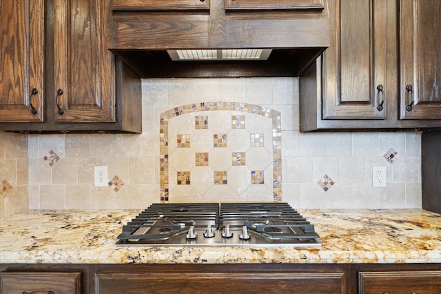 2508 Siskin Trl, League City, TX 77573 - kitchen featuring stainless steel gas cooktop, dark brown cabinets, ventilation hood, and tasteful backsplash