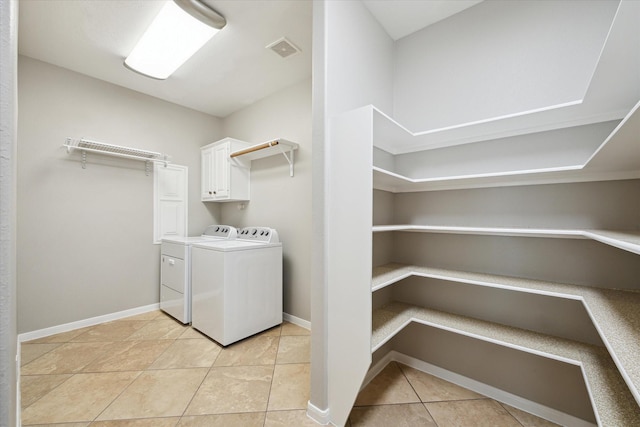 2508 Siskin Trl, League City, TX 77573 - laundry area with independent washer and dryer, cabinet space, and light tile patterned floors
