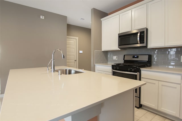 13333 Diamond Reef Ln, Texas City, TX 77568 - kitchen featuring appliances with stainless steel finishes, tasteful backsplash, a center island with sink, light countertops, and white cabinets