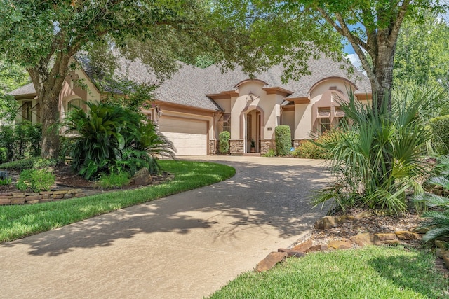 102 W Racing Cloud Ct, The Woodlands, TX 77381 - mediterranean / spanish home featuring stucco siding, concrete driveway, a garage, and stone siding
