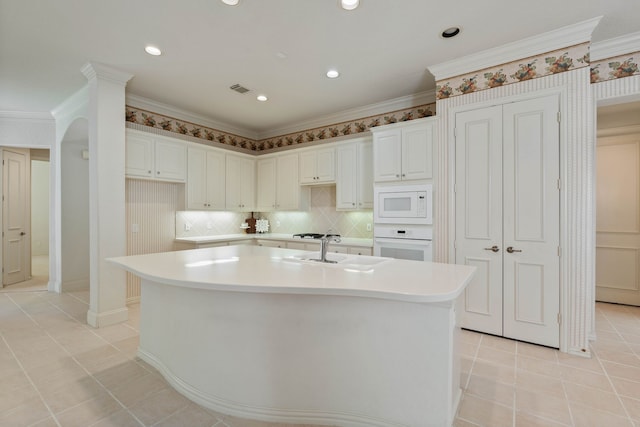 102 W Racing Cloud Ct, The Woodlands, TX 77381 - kitchen featuring white appliances, light tile patterned floors, light countertops, an island with sink, and crown molding