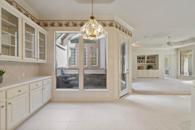 102 W Racing Cloud Ct, The Woodlands, TX 77381 - unfurnished dining area featuring a chandelier, built in features, a ceiling fan, ornamental molding, and a raised ceiling